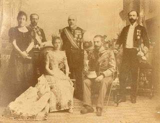 En el centro entre la infanta Eulalia de Borbón (tía de Alfonso XII) y su esposo Don Antonio de Orleáns duque de Galliera. Con uniforme de Teniente General D. Alejandro Rodríguez Arias